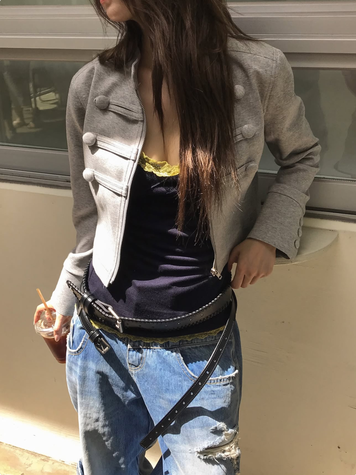 它的設計亮點在於胸前三對同色系立體盤扣裝飾、立領（Stand Collar）與前中拉鍊開襟，搭配袖口三顆同色包扣細節與修身短版剪裁，既有挺括的中性帥氣感，又能完美拉高腰線比例。